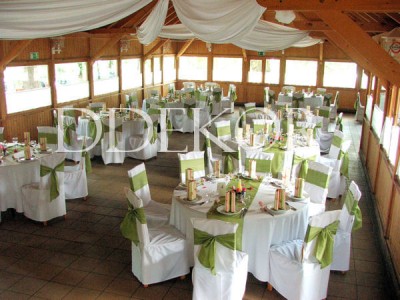 Hochzeitsdekoration mit Stuhlhussen, grünen Maschen und Servietten